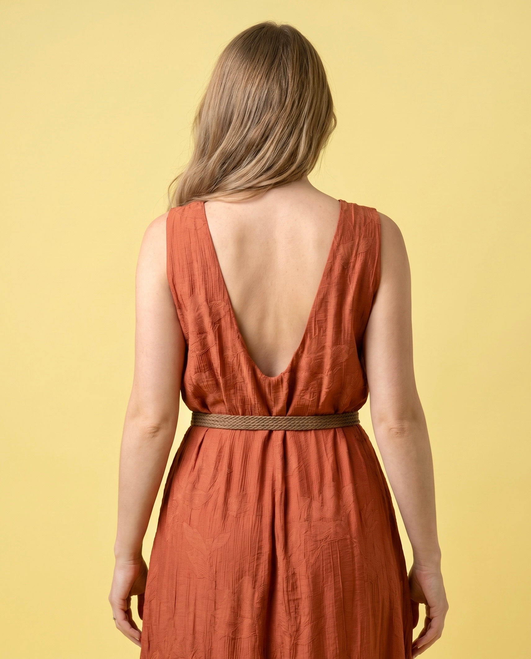 Tuta lunga terracotta con cintura intrecciata e scollo profondo sul retro